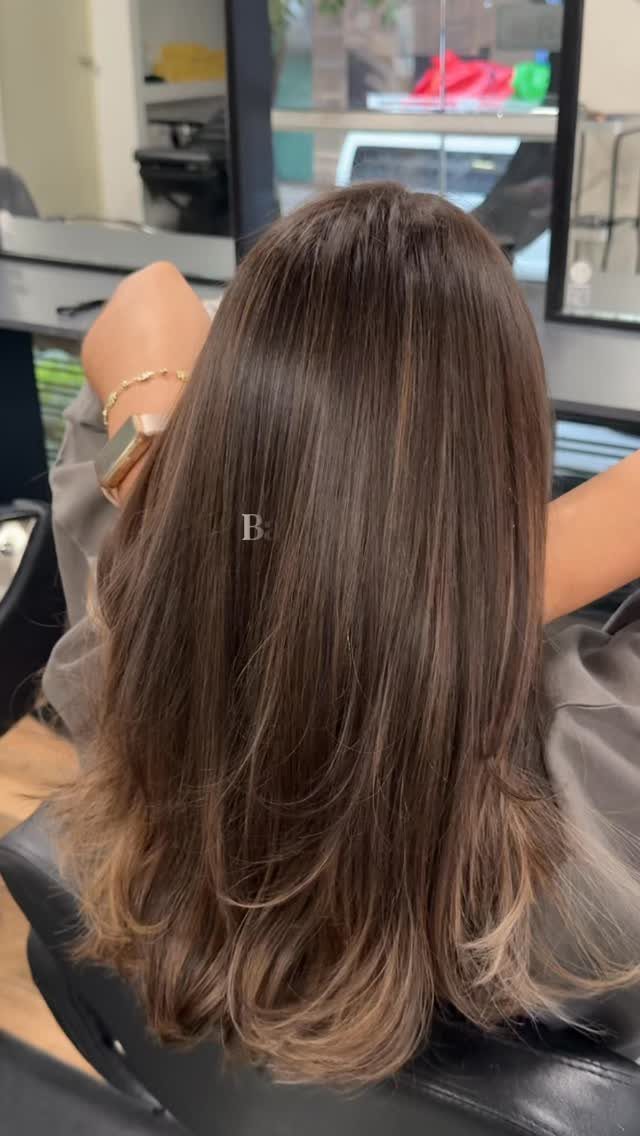 Long ash-brown hair with fine subtle highlights and softly curled ends