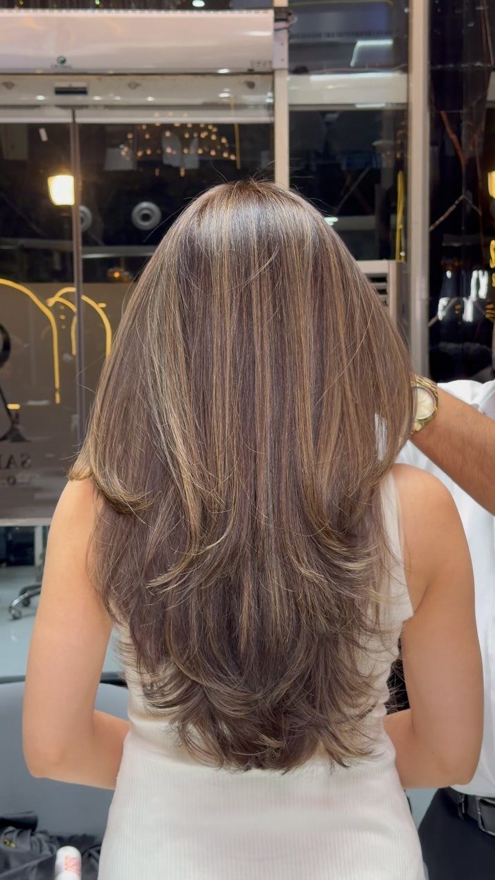 Long layered ash-brown hair with subtle beige balayage highlights