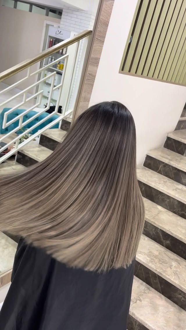 Straight ash-brown hair fades gradually from dark roots to lighter ends