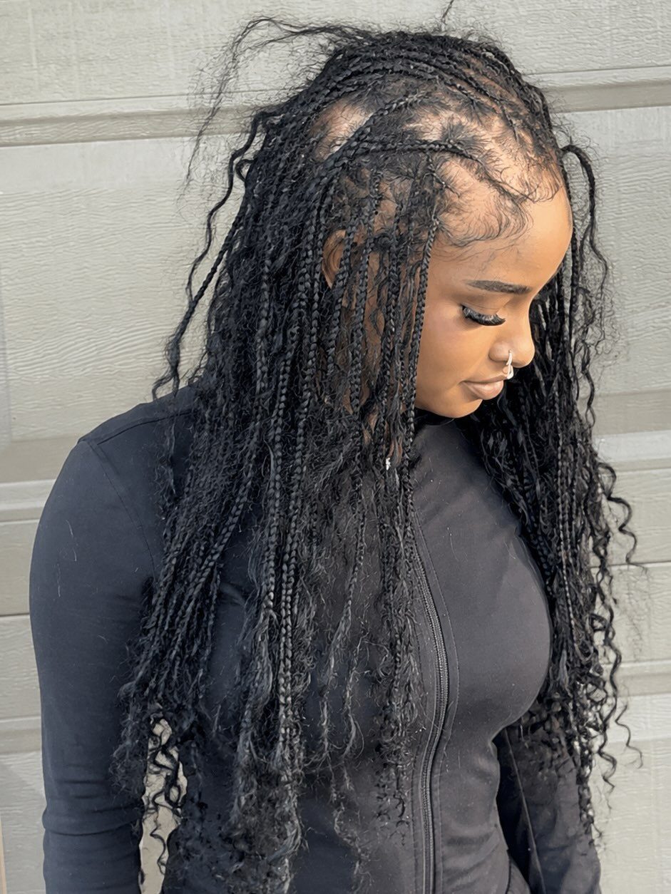 Woman with long black knotless braids and loose curly strands