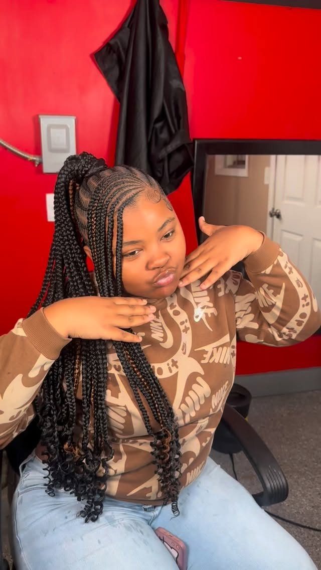 Woman poses with long black braids gathered into a high ponytail