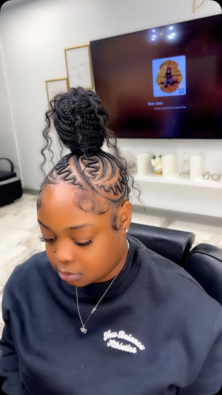 Black cornrows gather into a high braided knot with loose curls