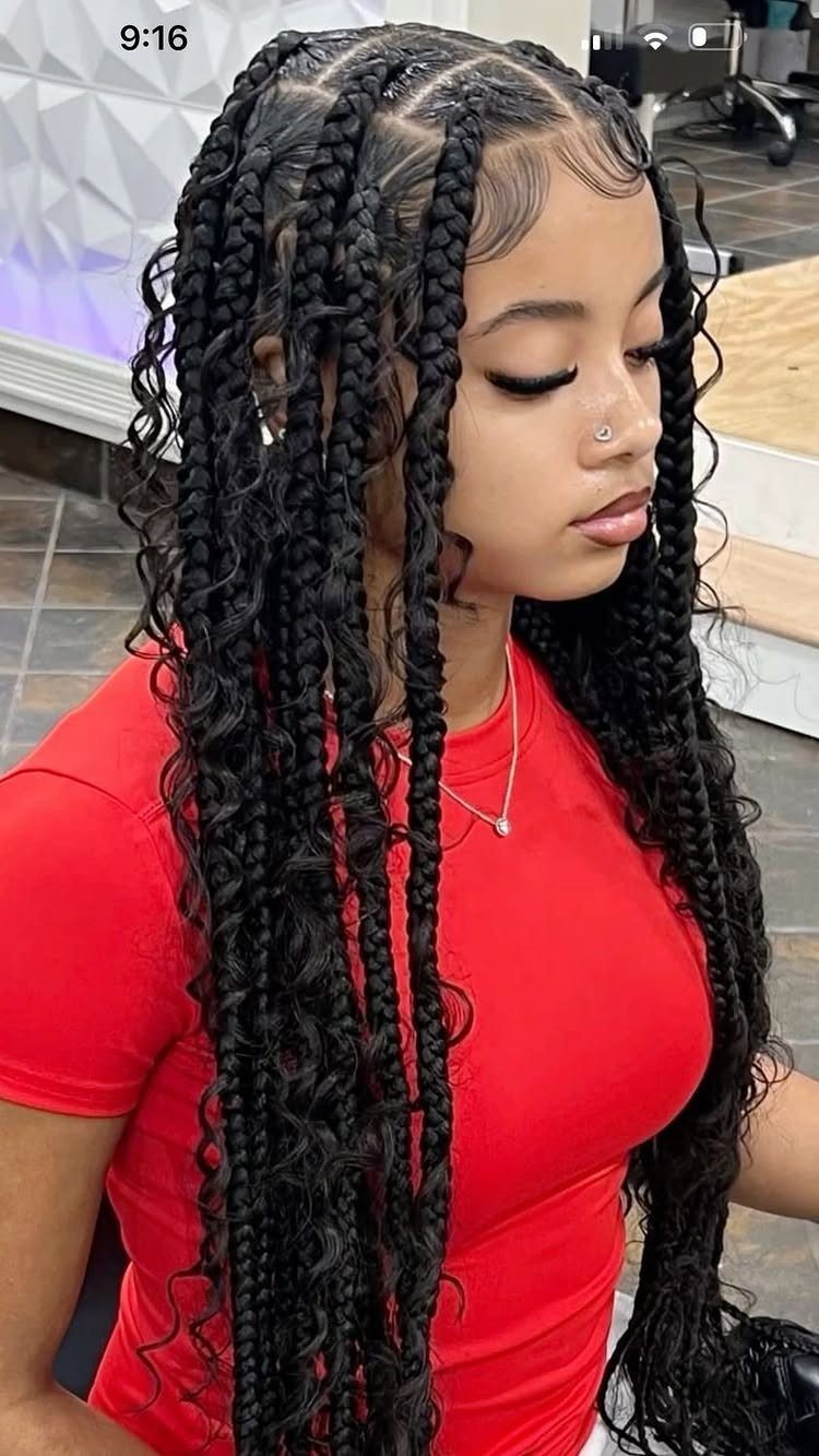 Woman wearing long, thick black braids with curled ends in a salon