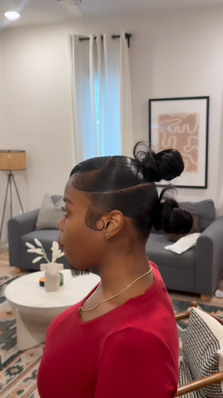 Side-profile person showing sleek swooped hair sections and stacked buns