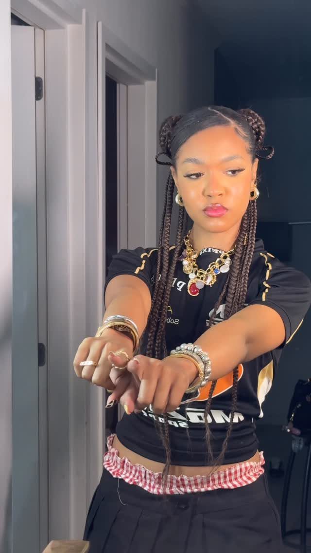 Woman wearing long braids gathered into two buns on top of her head