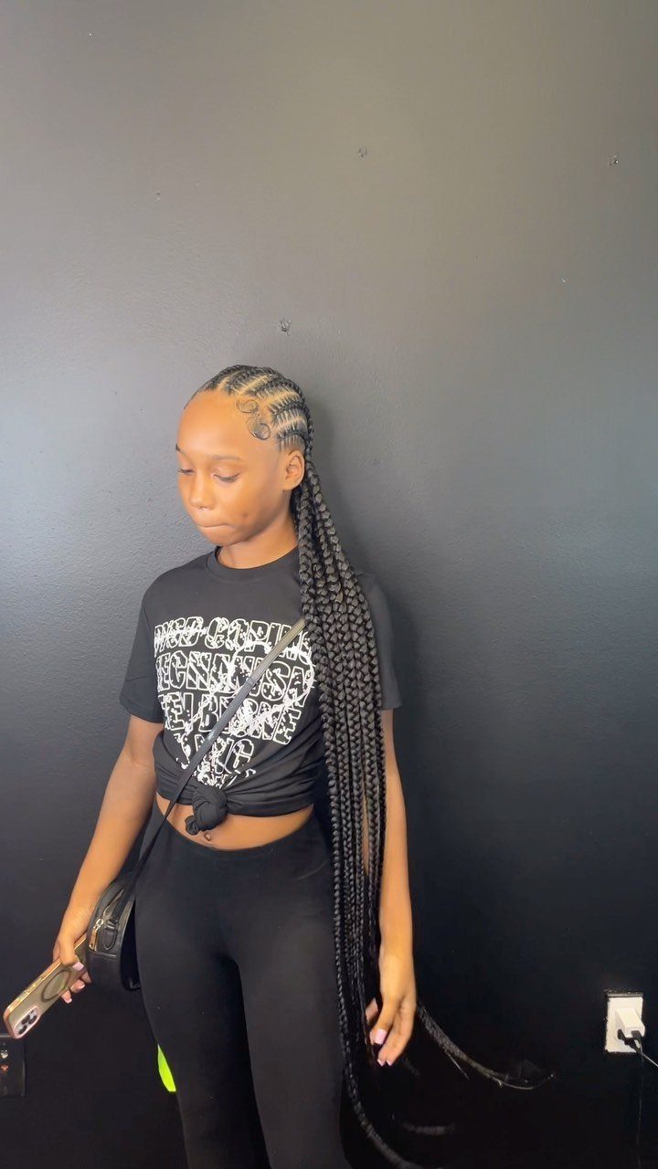 Woman with curved stitch cornrows leading into very long black braids
