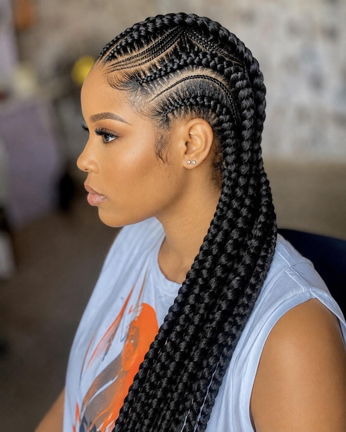 Woman with thick black straight-back cornrow braids flowing down her back