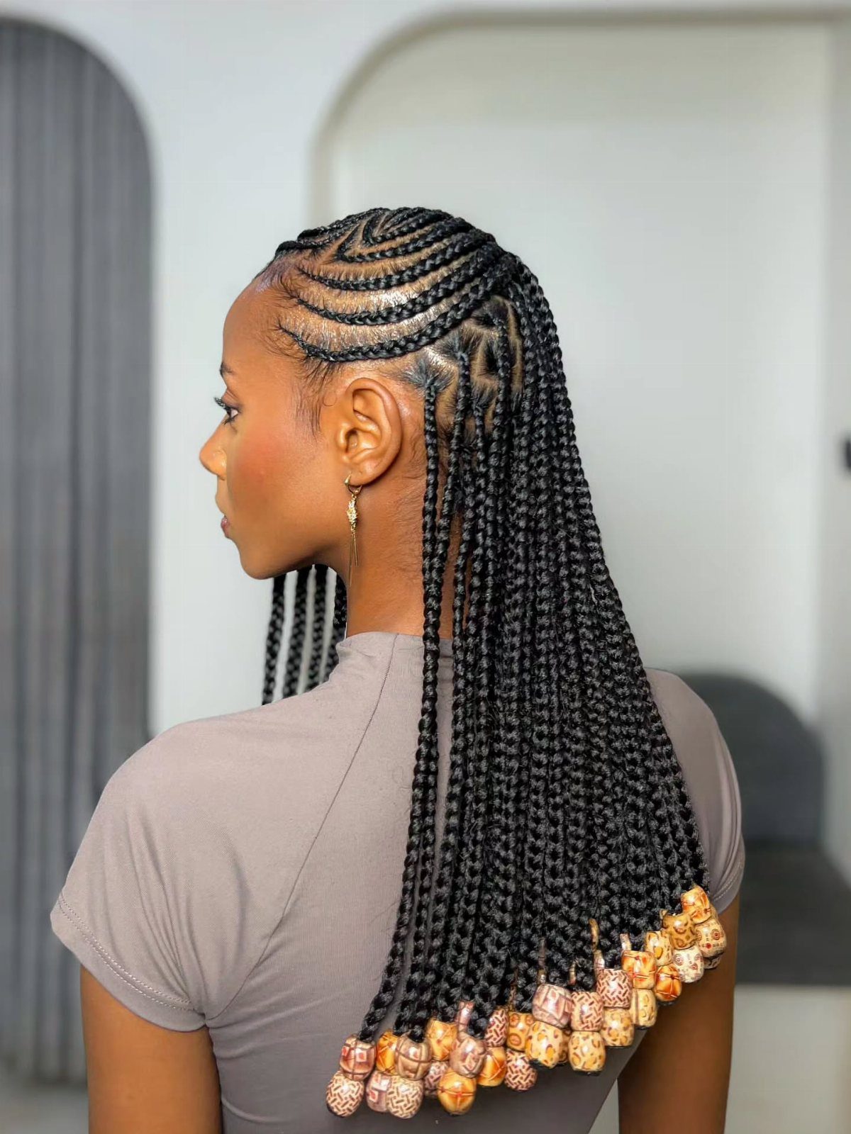 Straight-back cornrows flow into long braids finished with decorative beads