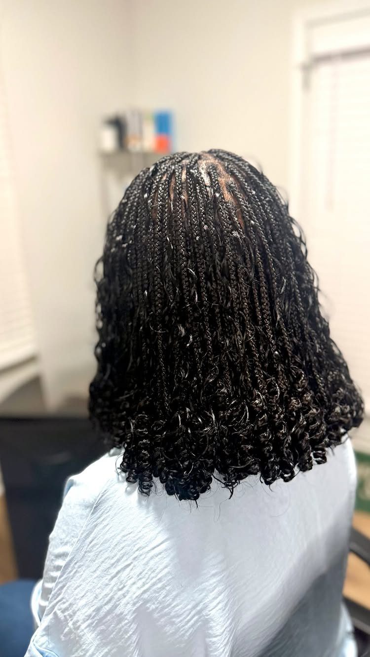 Shoulder-length black braids with curled ends form a rounded bob