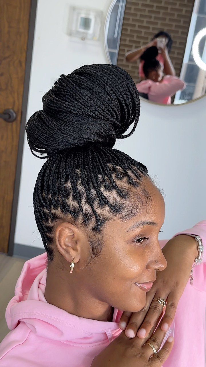 Woman showing neat black braids gathered into a large high bun