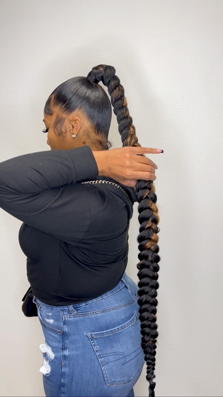 Woman showing a long, thick braided ponytail gathered high at the back