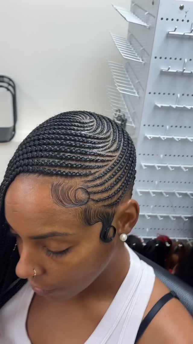 Black cornrows sweep in curved rows across the scalp with styled edges