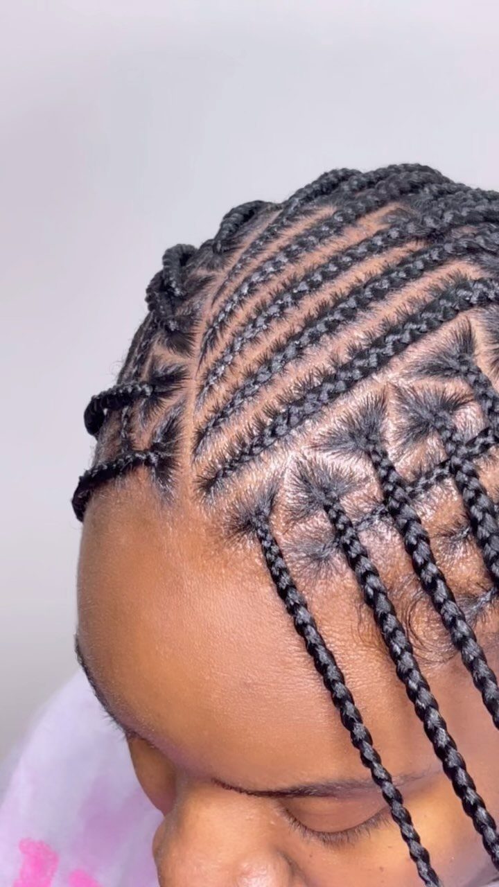 Black scalp cornrows with thin braids hanging forward on a person’s head