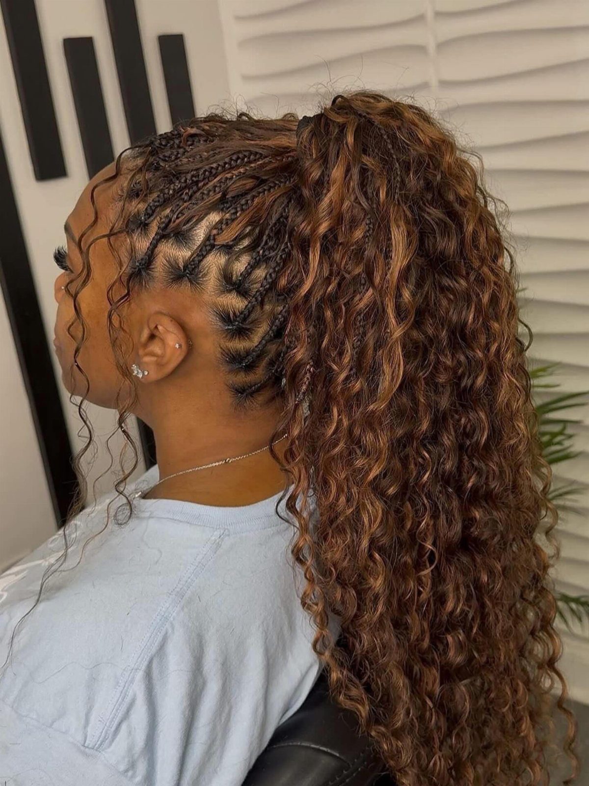 Long brown goddess braids with loose curls gathered into a voluminous high ponytail