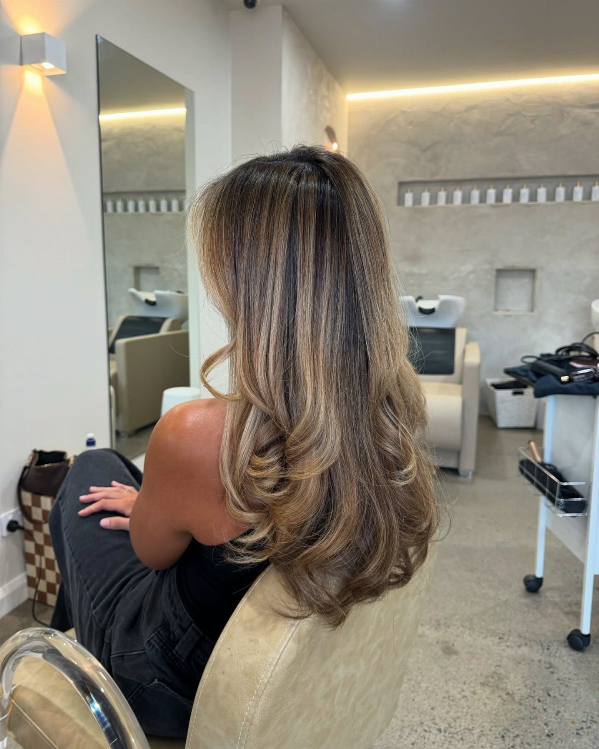 Long light brown hair with soft beige highlights in layered salon styling