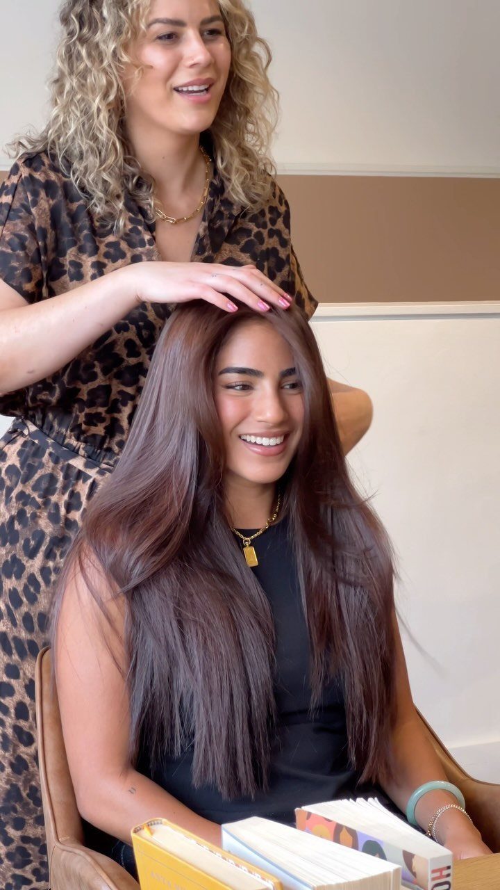 Woman with long, straight espresso-brown hair sits in a salon