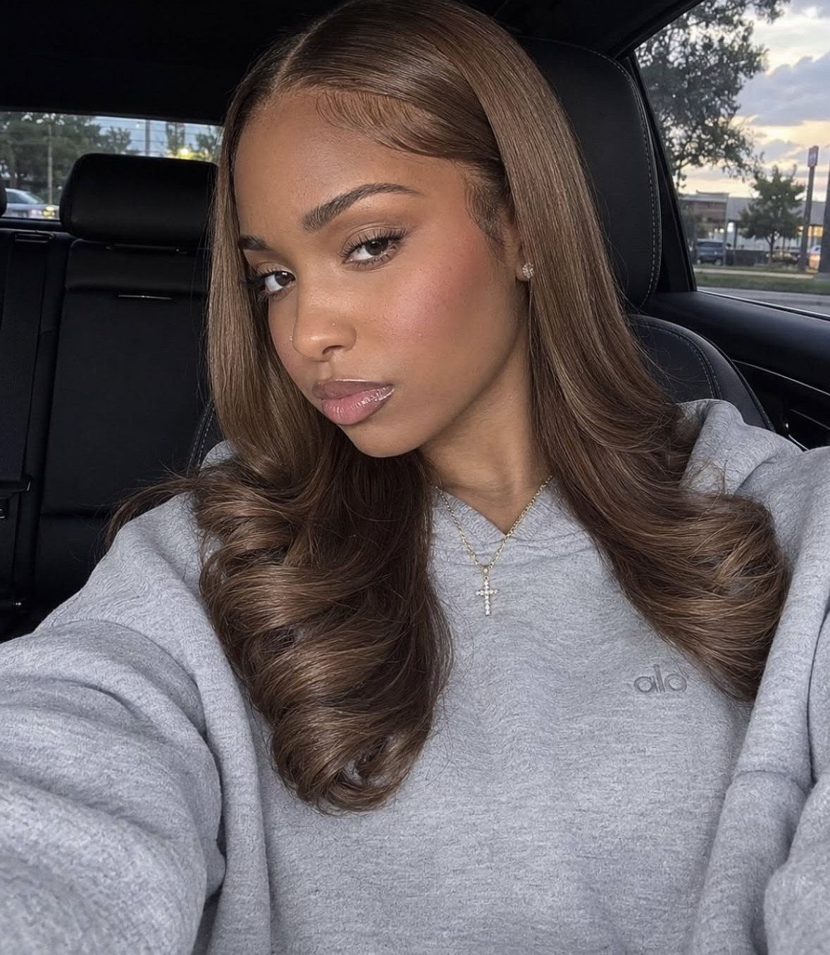 Woman showing long, light brown curls while sitting in a car