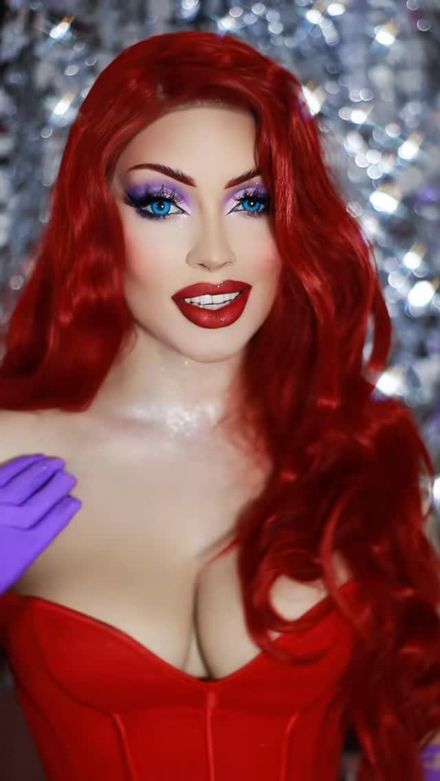 Jessica Rabbit cosplayer with side-swept red waves, red dress and purple gloves