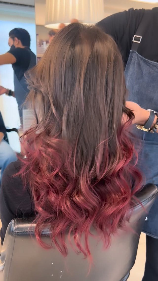 Long brunette hair blending into burgundy-red balayage curls at the ends