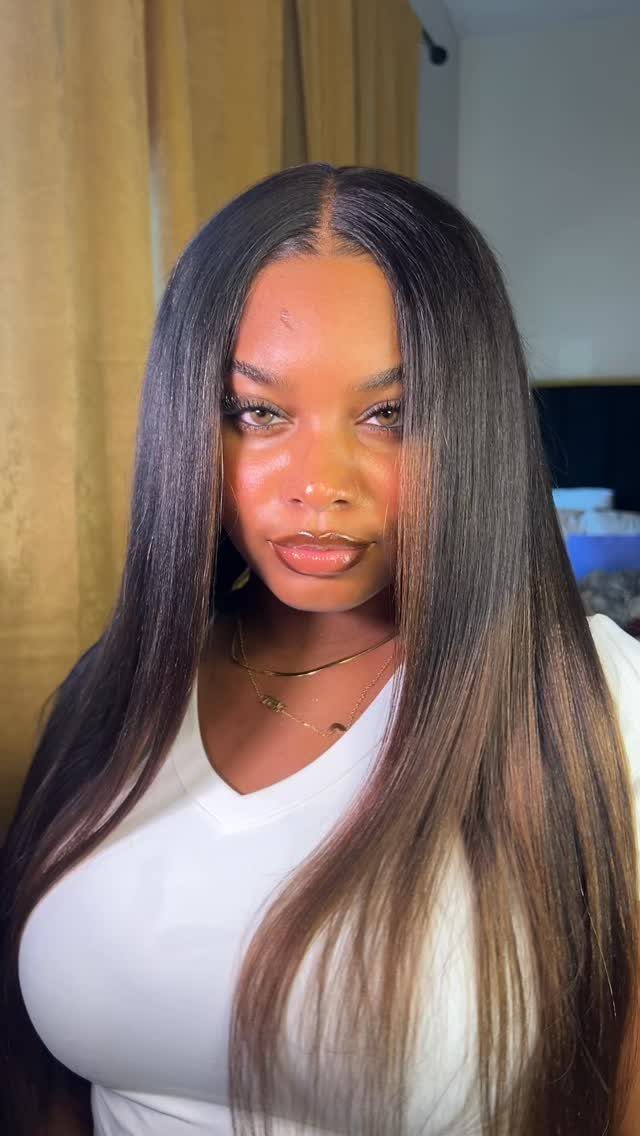 Woman with long straight hair fading from dark roots to chestnut-brown ends
