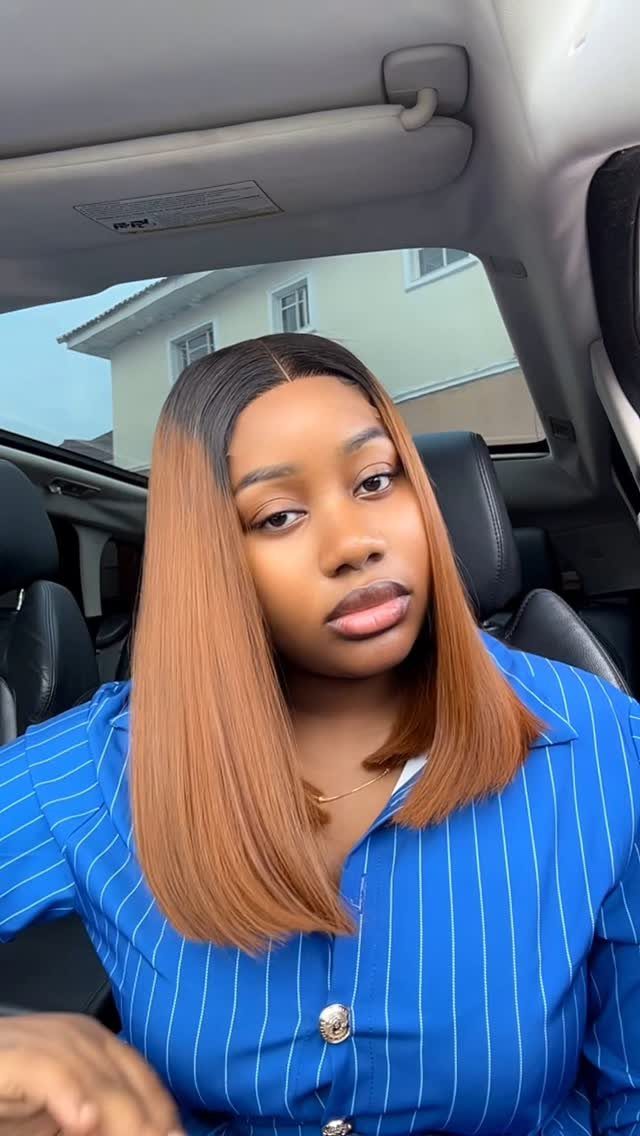 Woman with straight chestnut hair and dark roots sitting in a car