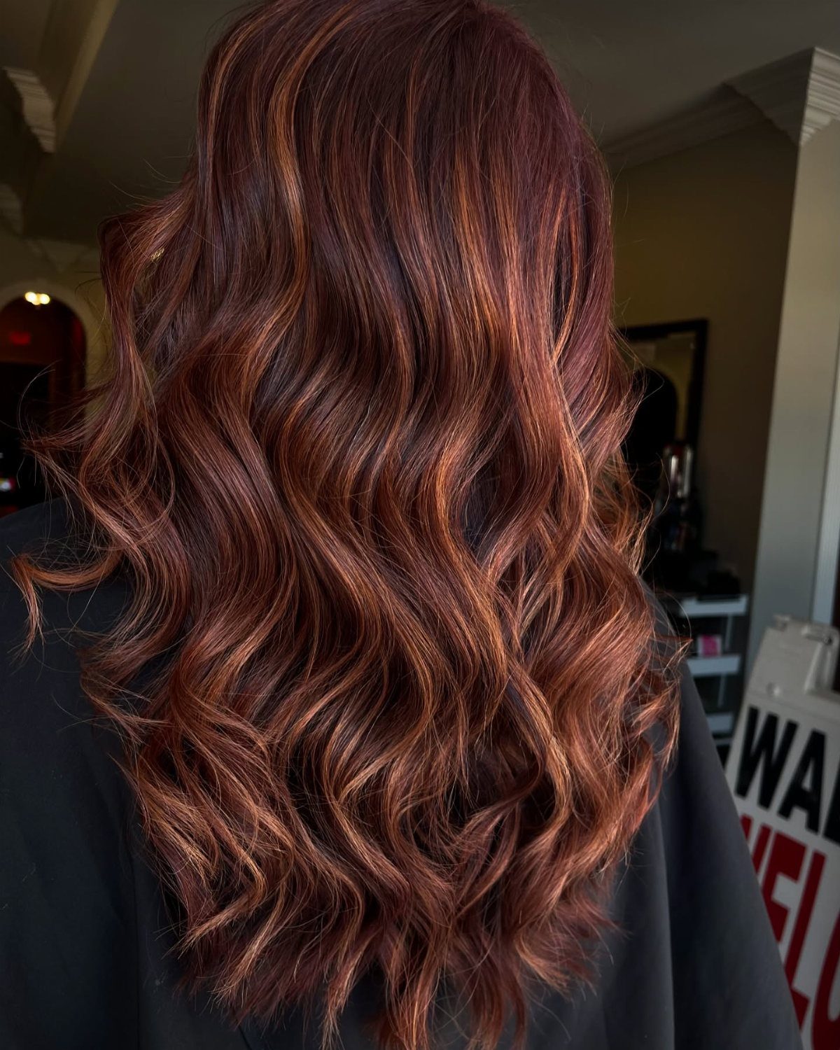 Chestnut hair with wavy red and golden highlights viewed from behind