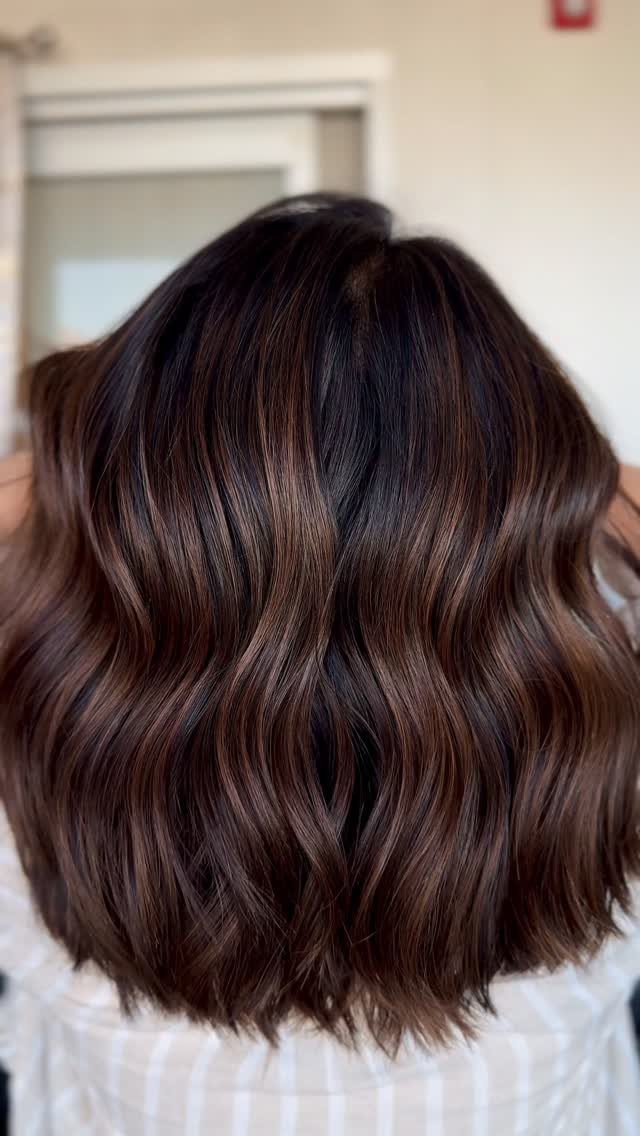 Wavy dark brown hair with chestnut and copper-red balayage highlights