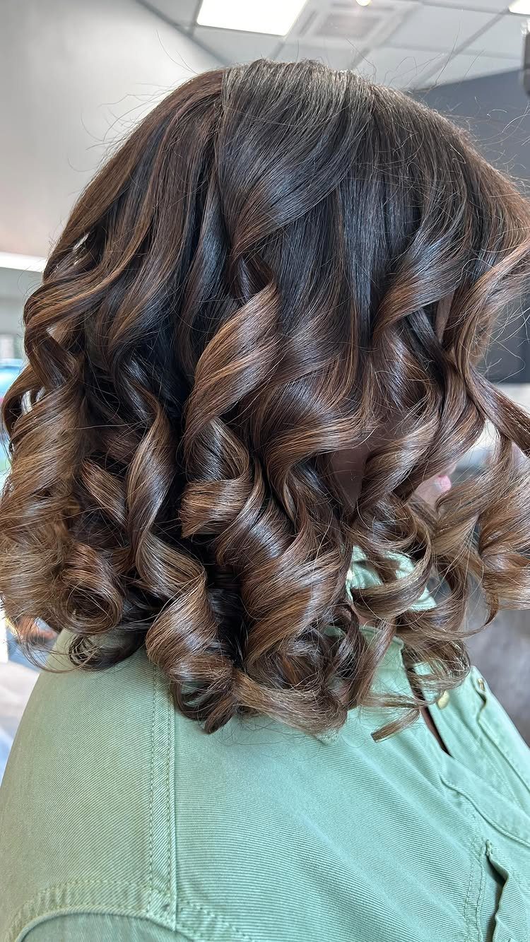 Chocolate-brown bob with warm highlights styled in glossy loose curls