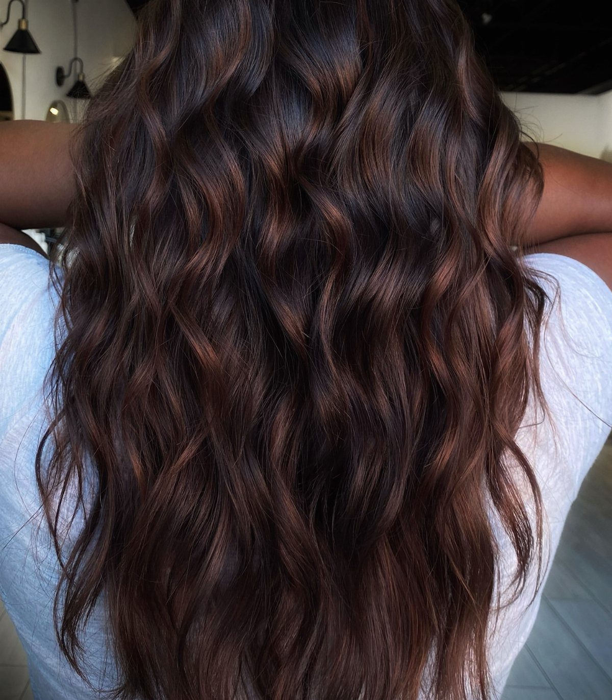 Long dark chocolate waves show subtle chestnut and mahogany highlights.
