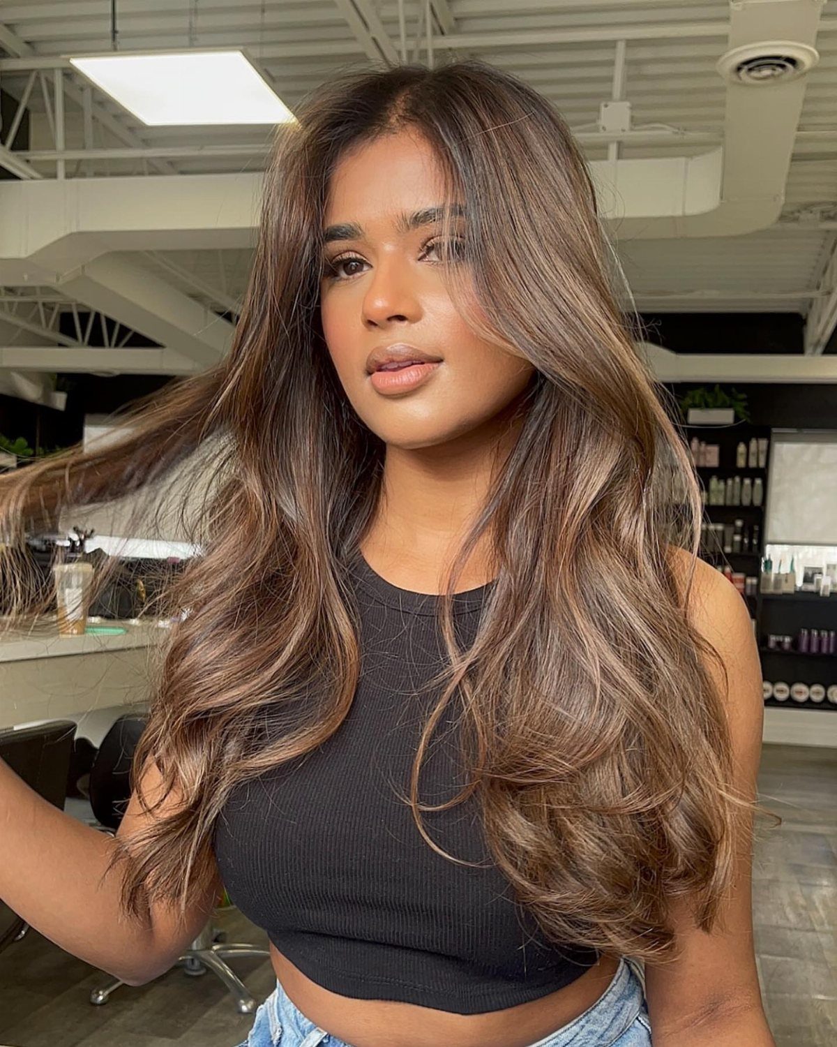 Woman with long wavy brunette hair showing a soft, subtle ombré