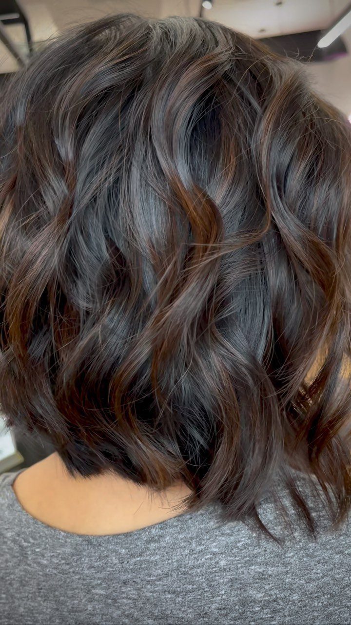 Wavy dimensional brunette lob with dark chocolate-brown and lighter brown strands