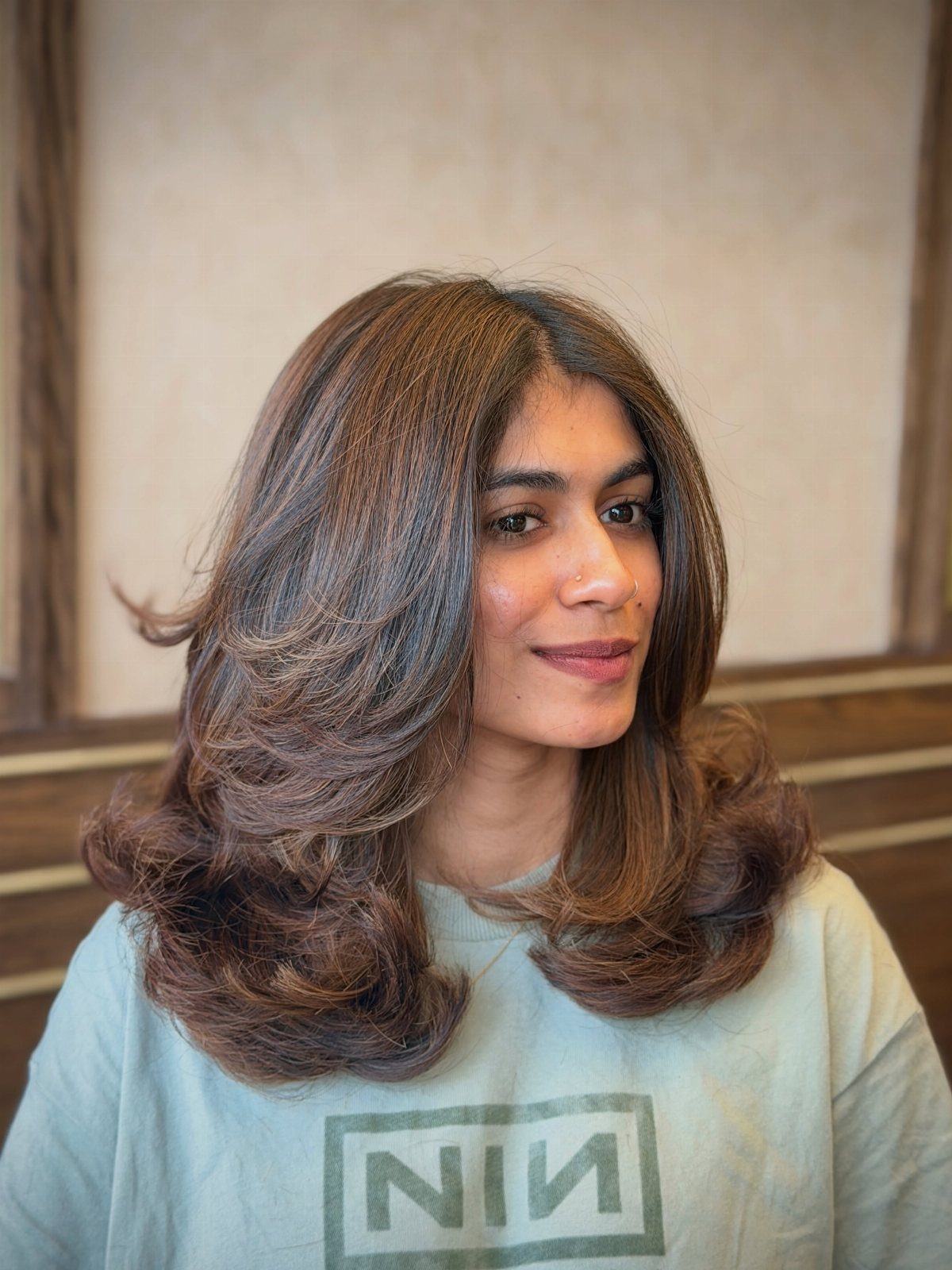 Woman wearing voluminous, layered chocolate-brown hair with curled ends
