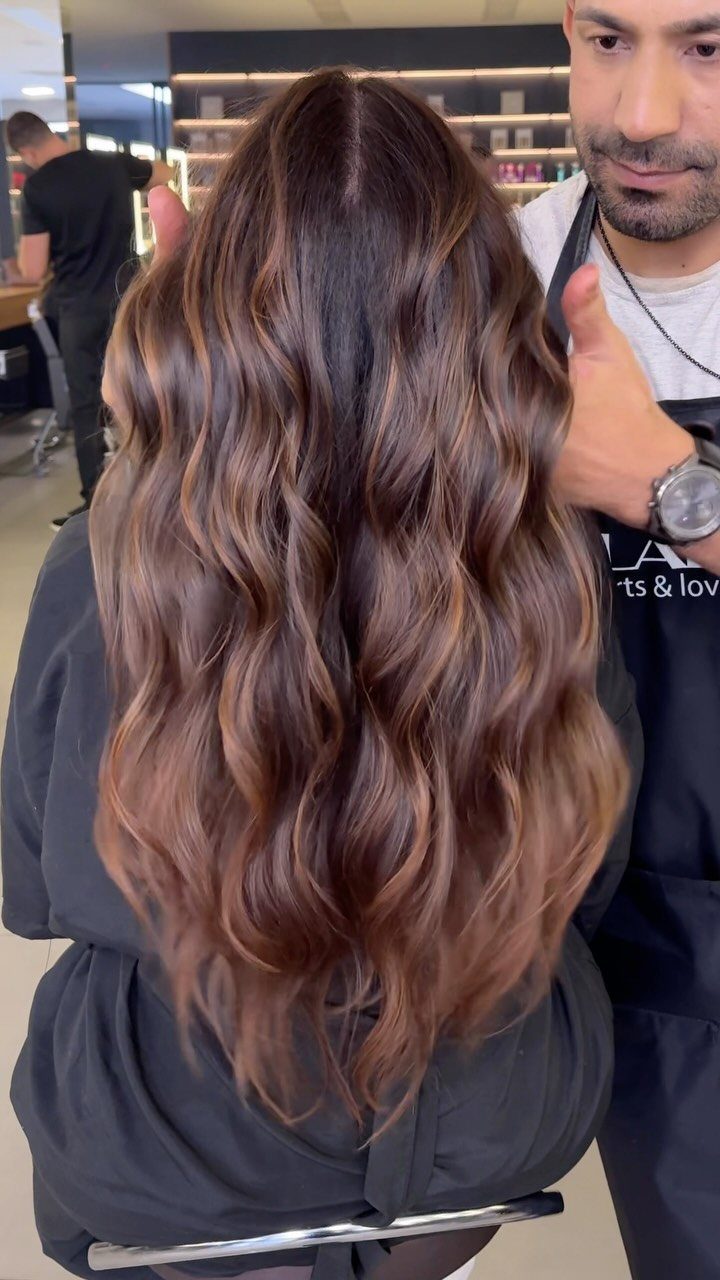 Long chocolate-brown balayage hair with softly blended lighter brown waves
