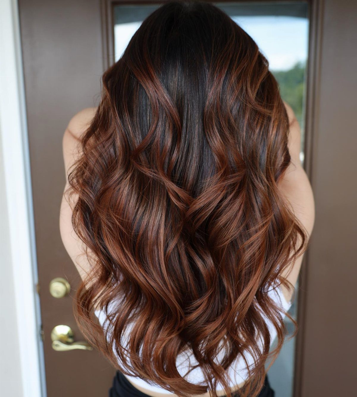 Wavy dark brown hair with copper streaks through the middle lengths