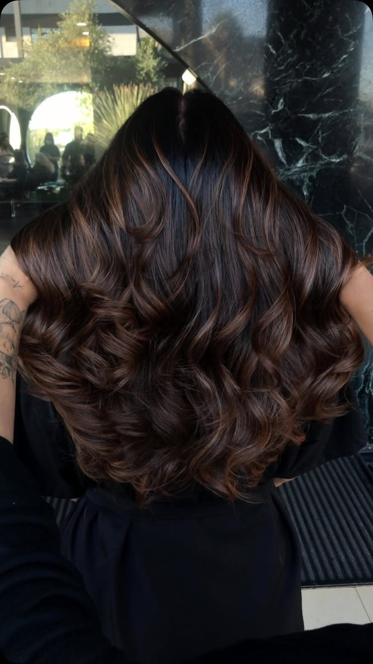 Wavy espresso brown hair with subtle hazelnut ribbons and glossy curls