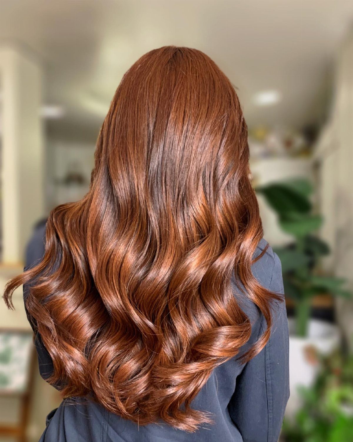Long bright auburn copper hair styled in glossy waves down the back