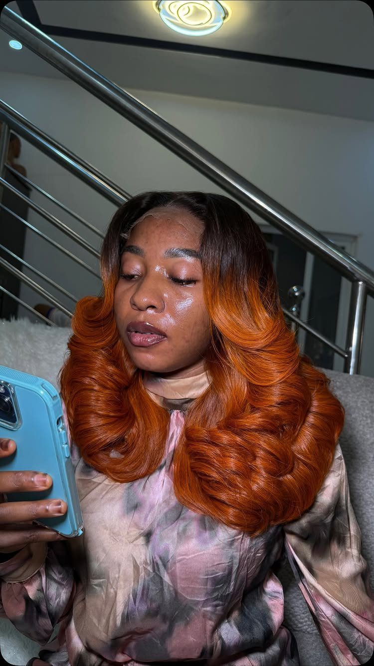 Woman's voluminous burnt-orange copper hair curls around her shoulders