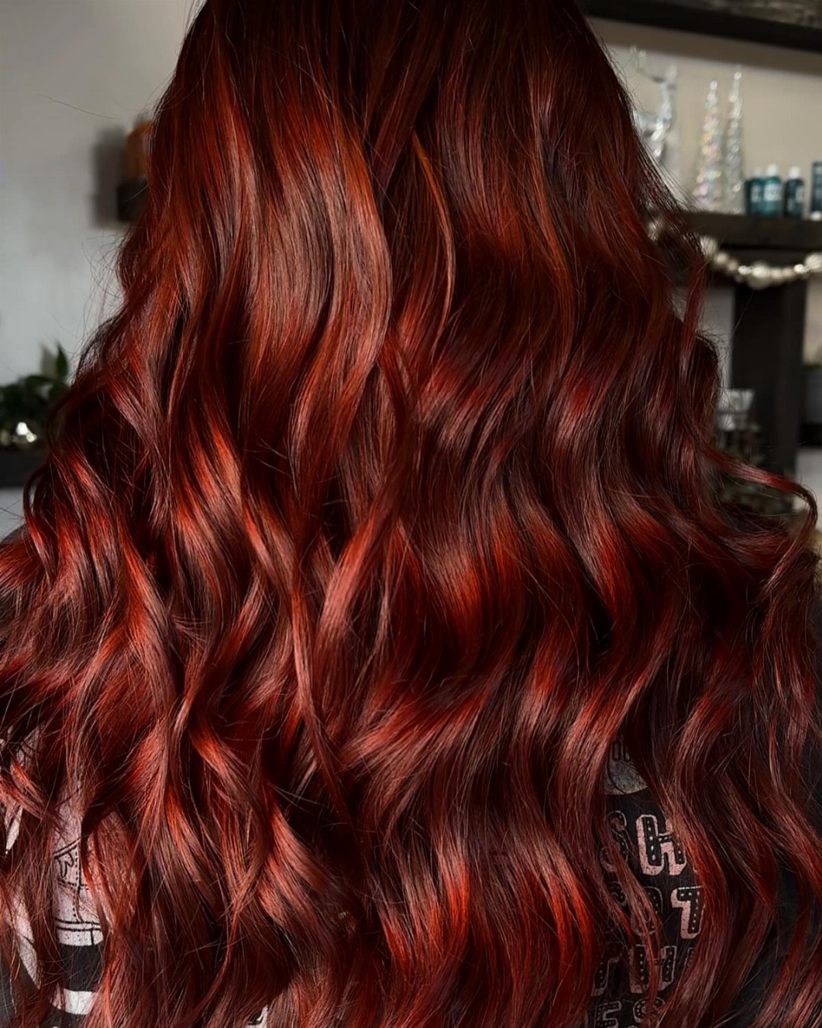 Glossy wavy reddish-brown hair with bright copper highlights