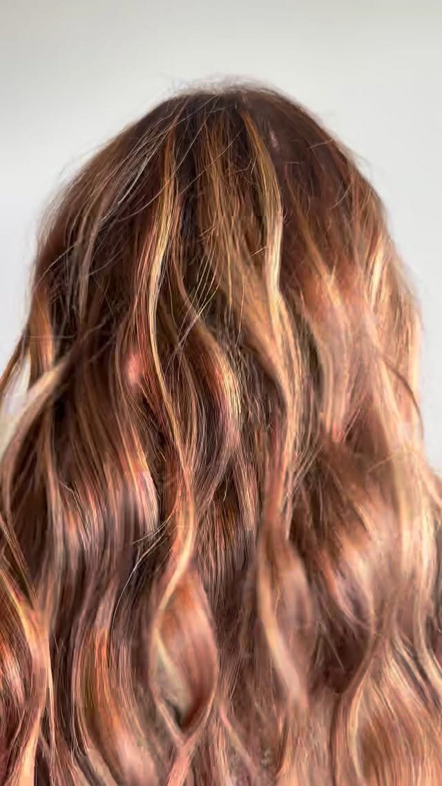 Wavy dark brown hair with copper and golden blonde blended highlights