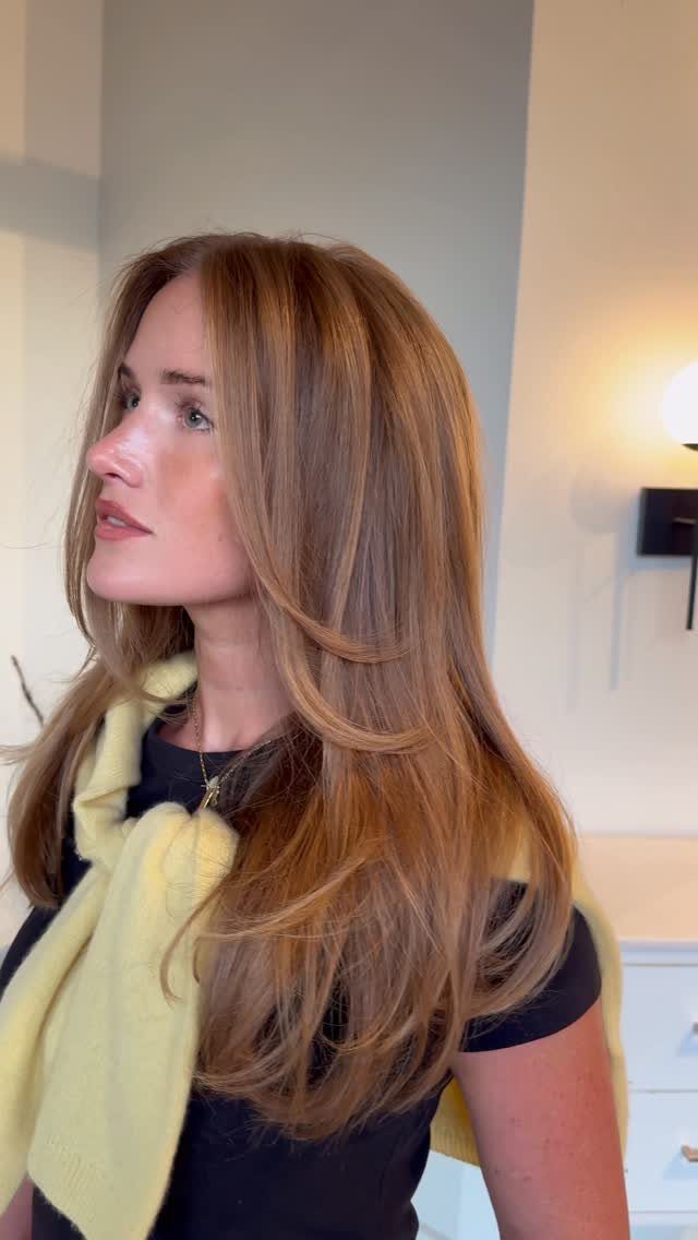 Woman showing long layered strawberry-copper brown-blonde hair