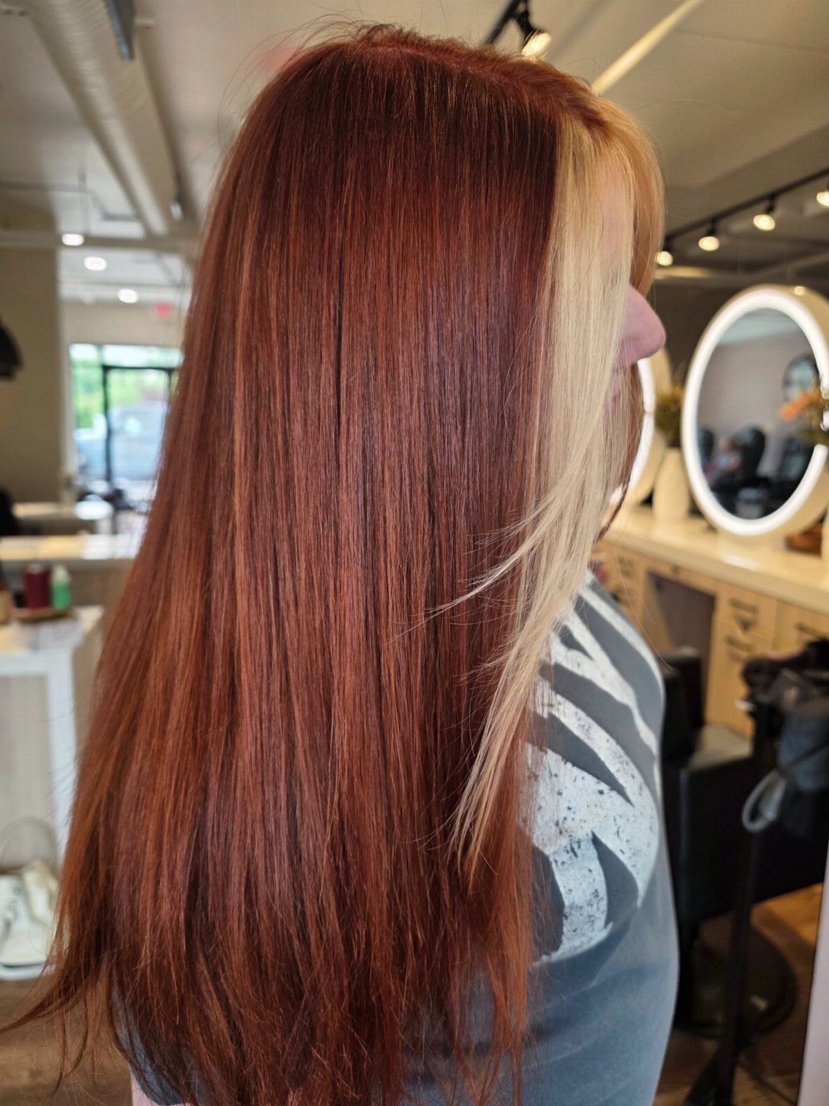 Long copper-brown hair with a distinct lighter copper section framing the face