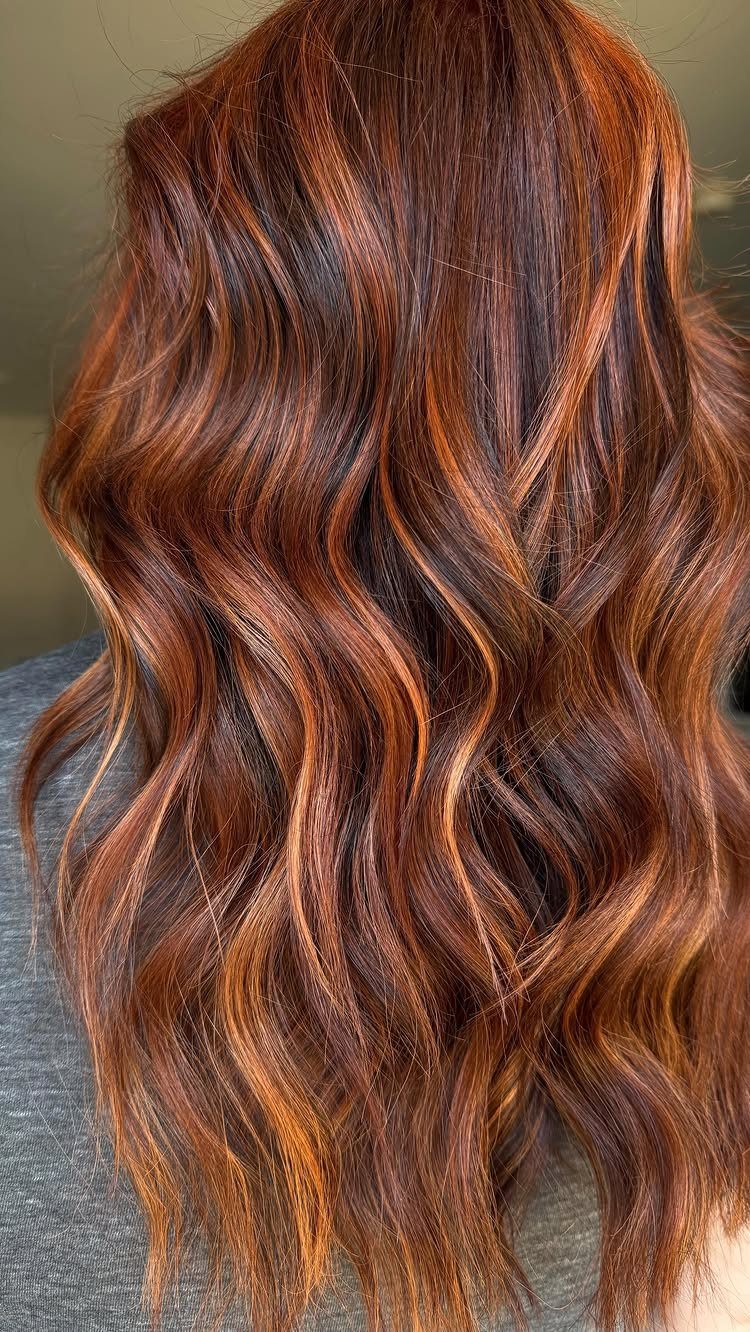 Wavy brown hair with copper highlights cascading down the back