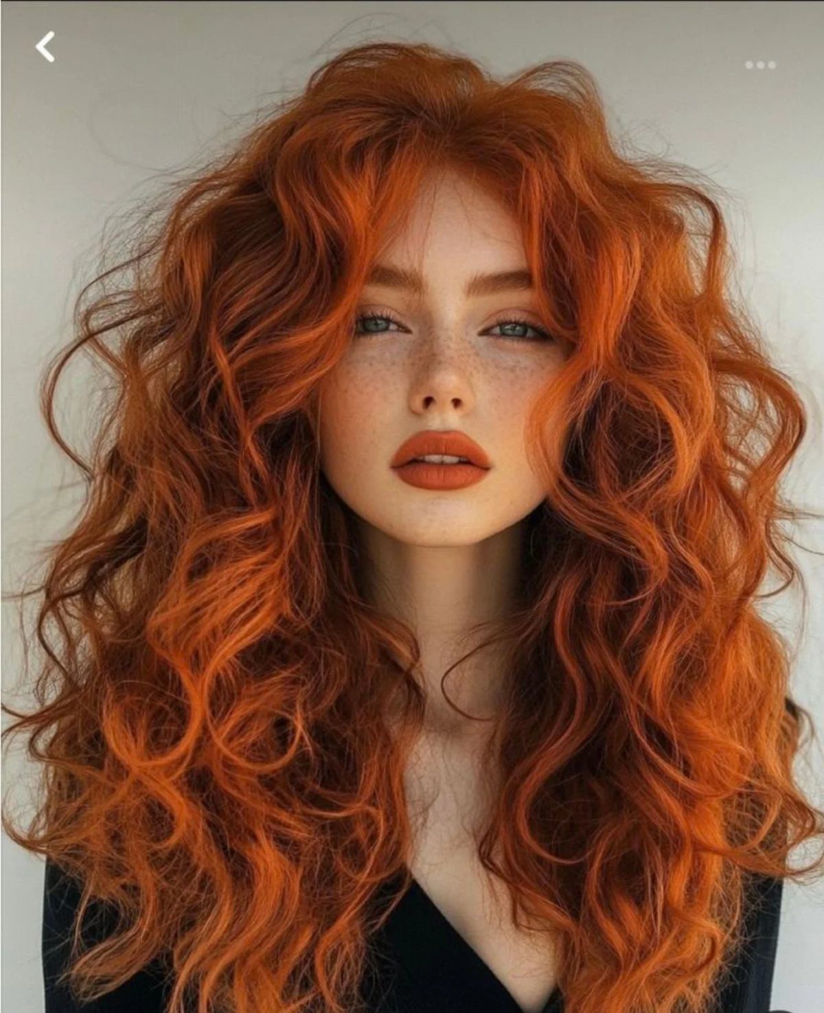 Woman with long, voluminous red velvet copper curls and freckles