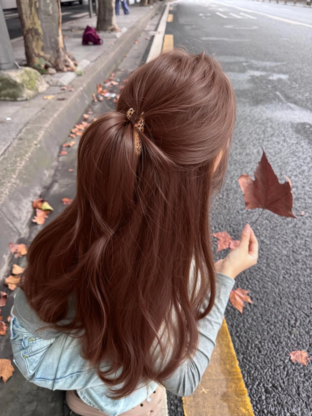 Long wavy rusty copper hair tied partly back with a gold clip