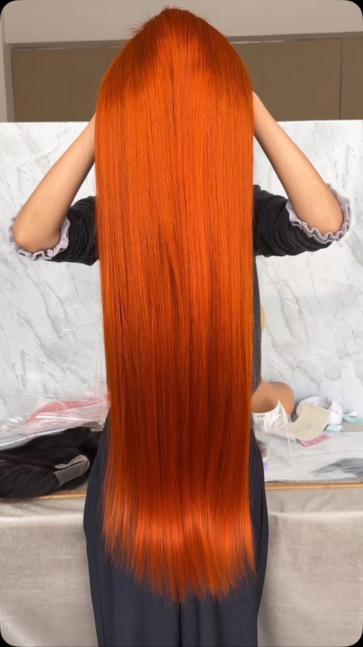 Long, glossy vivid orange-red copper hair shown from behind
