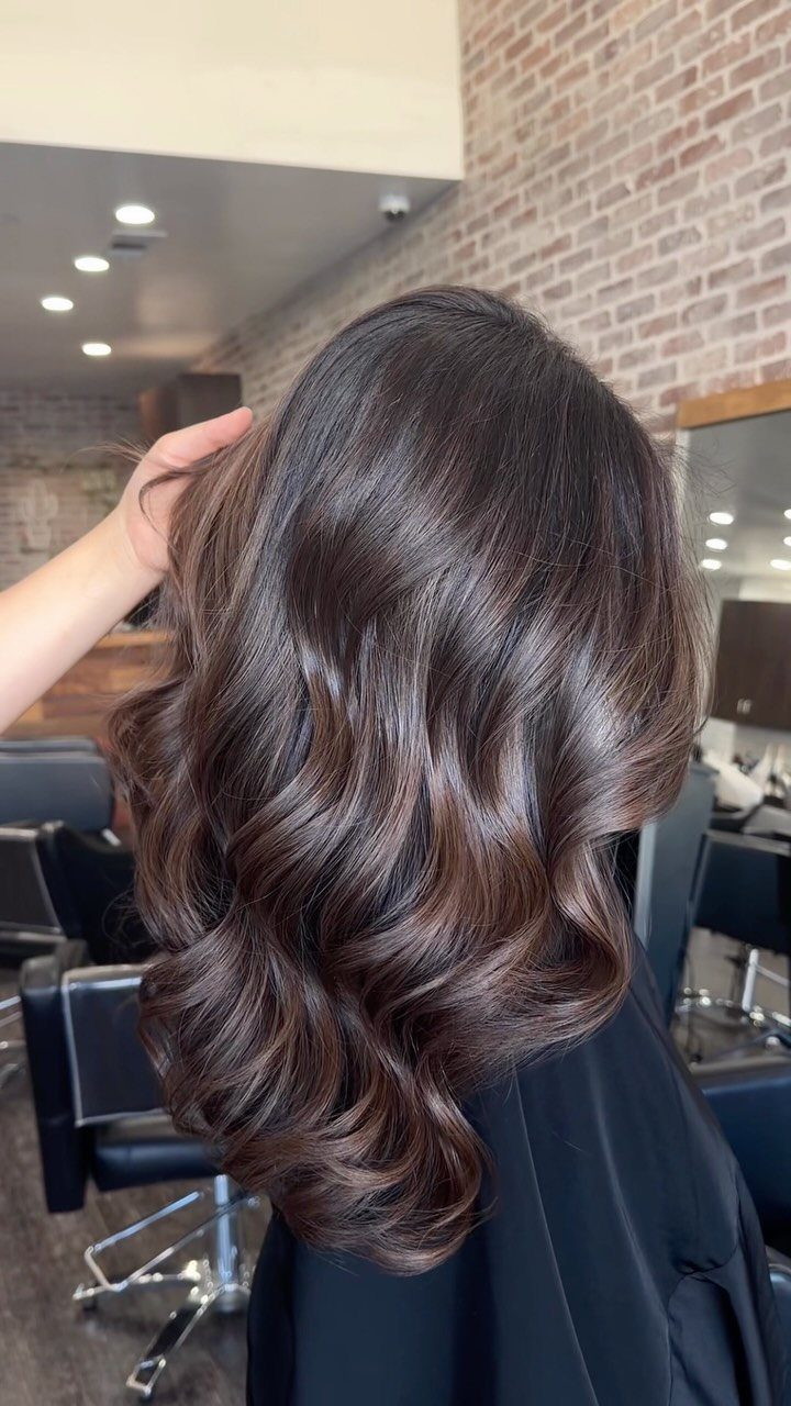 Wavy dark mocha brunette hair with glossy dimensional brown highlights