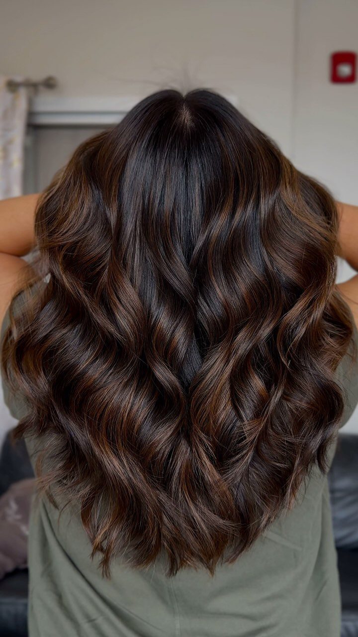 Long espresso-brown hair styled in glossy, loose waves