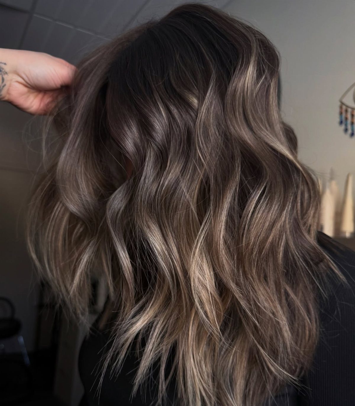Wavy brunette hair with soft sandy beige blonde highlights viewed from behind