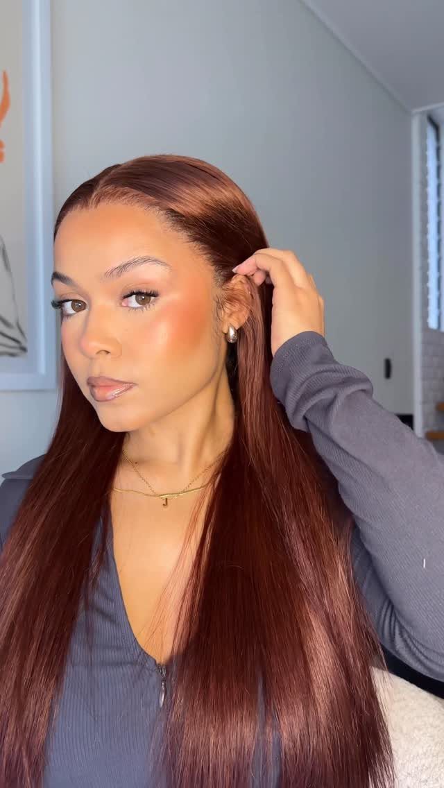Woman showing long, straight auburn-brown hair with a glossy finish