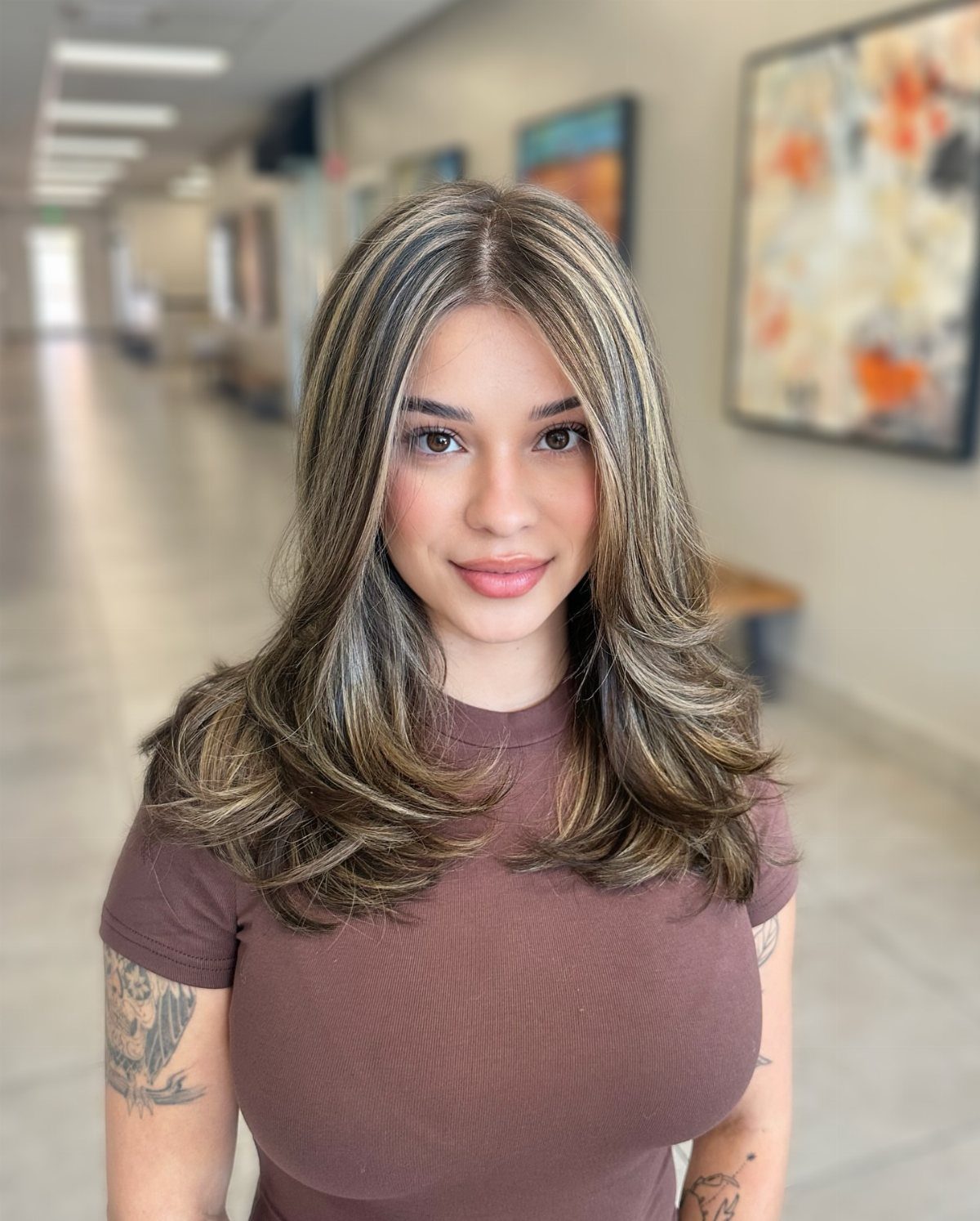 Woman showing layered dark brown hair with contrasting blonde highlights